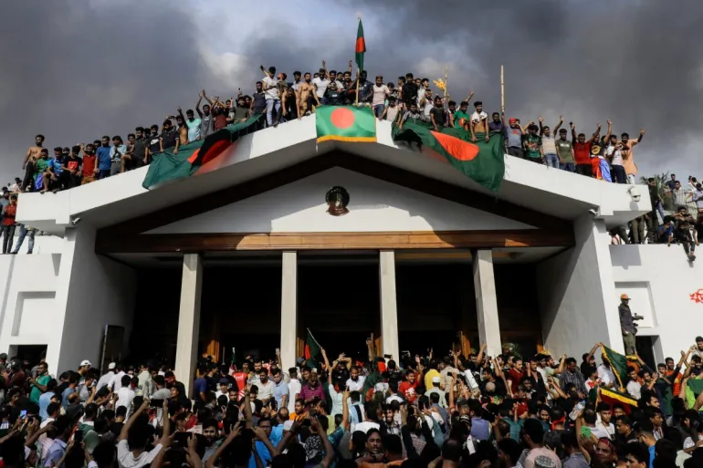Protesters with Bangladesh flags atop the Prime Minister's residence after Sheikh Hasina fled, August 5 2024